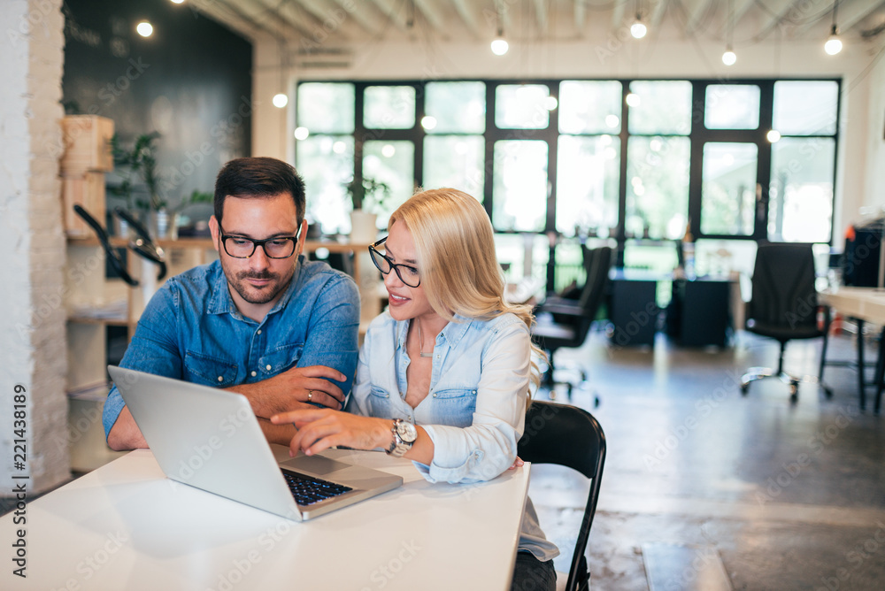 Two beautiful young designers working together in modern co-working office. Two beautiful young designers working together in modern co-working office.