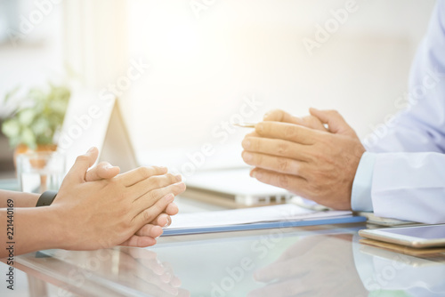 Foto Clasped hands of unrecognizable medical practitioner and patient over table in d