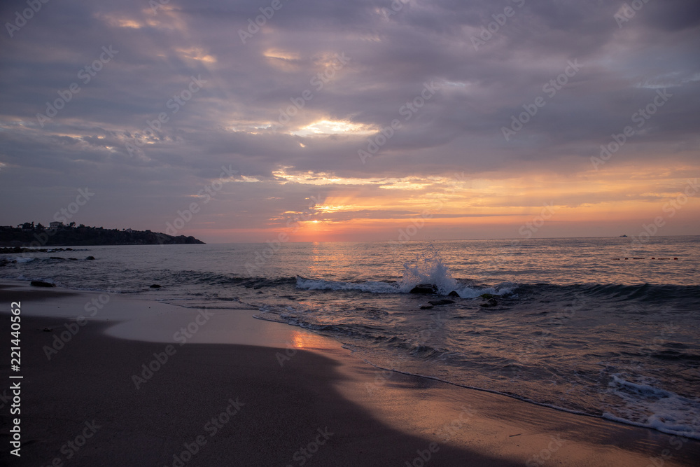 Waves on the beach at cloudy sunset
