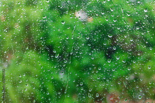 Water drops on glass surface on a green background