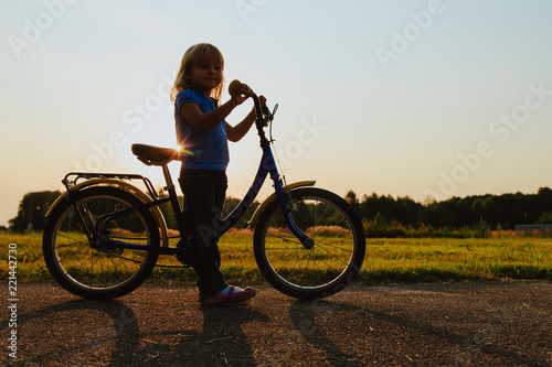 Fototapeta Naklejka Na Ścianę i Meble -  little girl riding bike at sunset