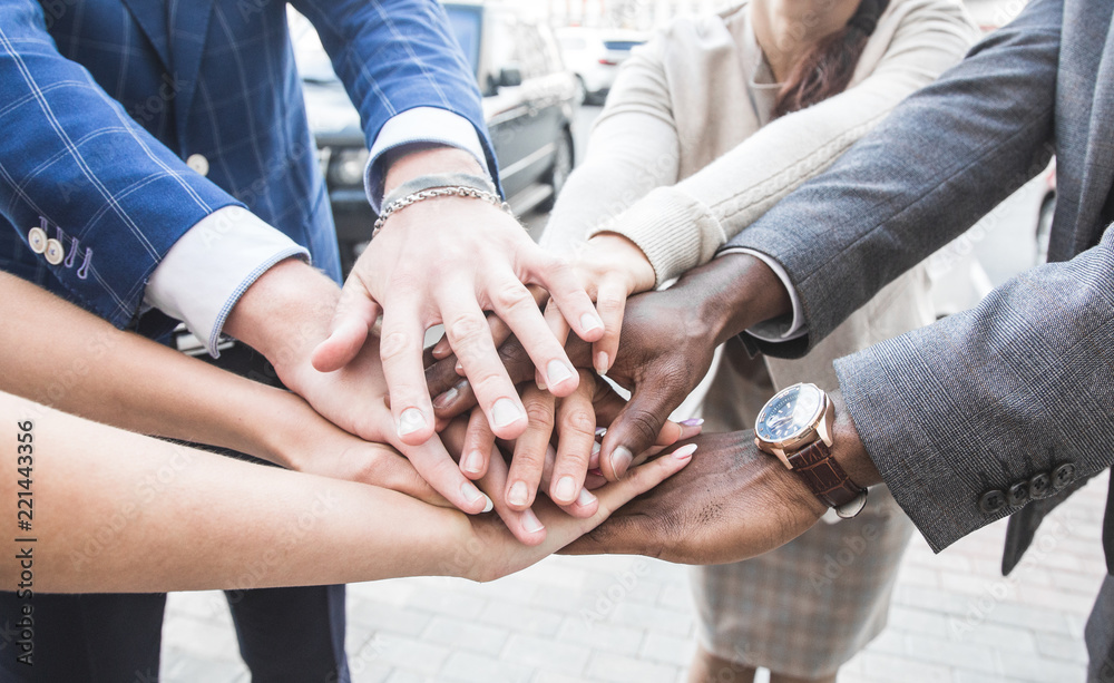 Obraz premium business, people and teamwork concept - smiling group of businesspeople standing in circle and putting hands on top of each other