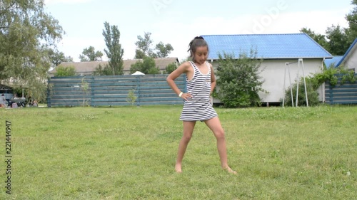 Young girl dancing fun in the summer park dressed T-shirt