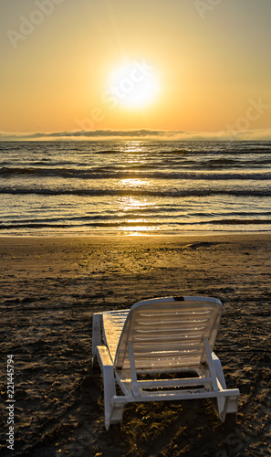 Sunbeds on the beach of Black Sea at sunrise  warm sunshine atmosphere