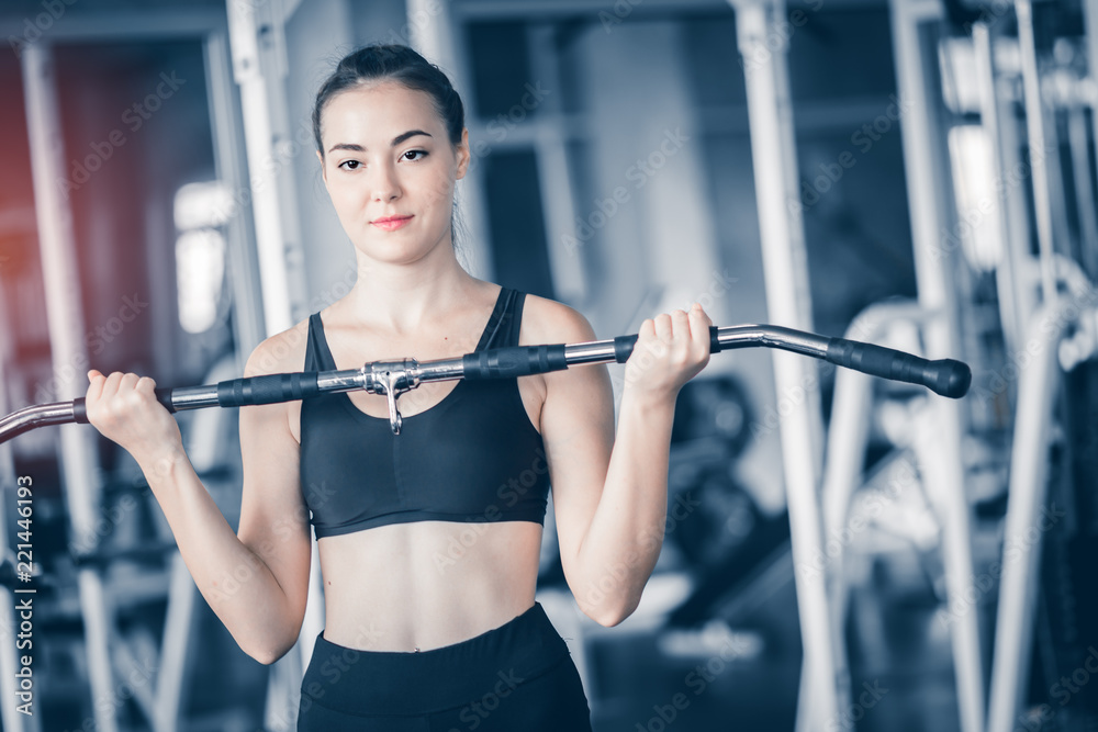 Fit beautiful young woman caucasian posing at the camera in sportswear. Young woman holding dumbbell during an exercise class in a gym. Healthy sports lifestyle, Fitness concept. With copy space. Fit beautiful young woman caucasian posing at the camera in sportswear. Young woman holding dumbbell during an exercise class in a gym. Healthy sports lifestyle, Fitness concept. With copy space.