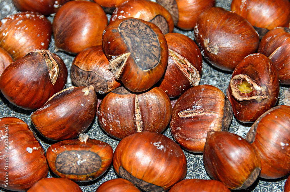 Edible brown cracked chestnuts close up, frying pan Edible brown cracked chestnuts close up, frying pan