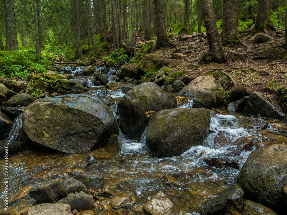 Mountain waterfall with blue, clear water. Summer background