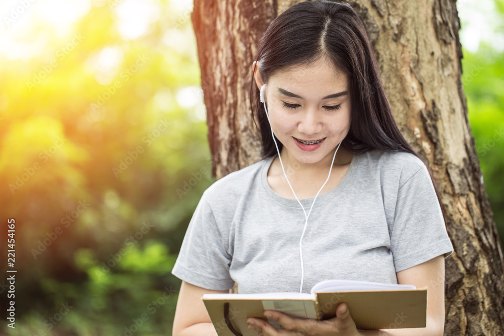 Beautiful attractive Asian young woman smile and reading book to learn and relax with nature in garden feeling so comfortable,Education learning Concept Beautiful attractive Asian young woman smile and reading book to learn and relax with nature in garden feeling so comfortable,Education learning Concept