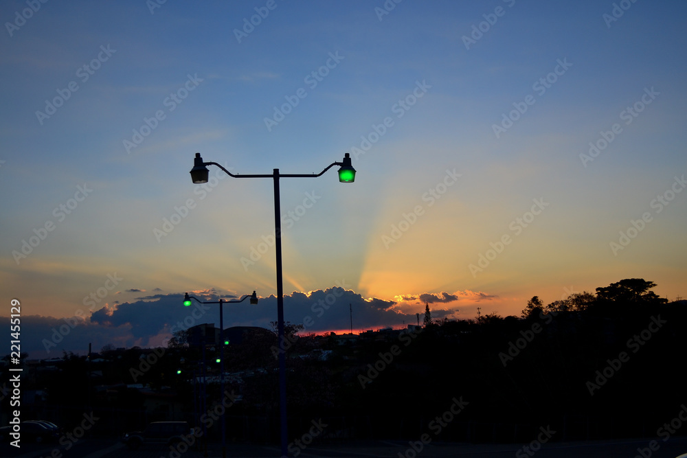 sunset with silhouette of street lamp