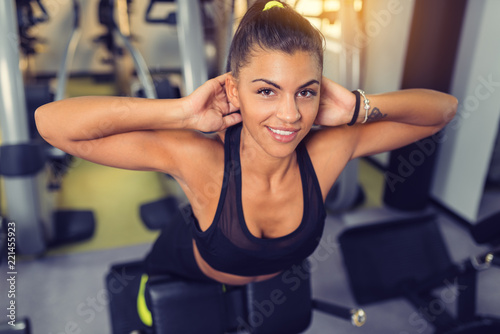 Young woman exercising back on roman chair In the gym.