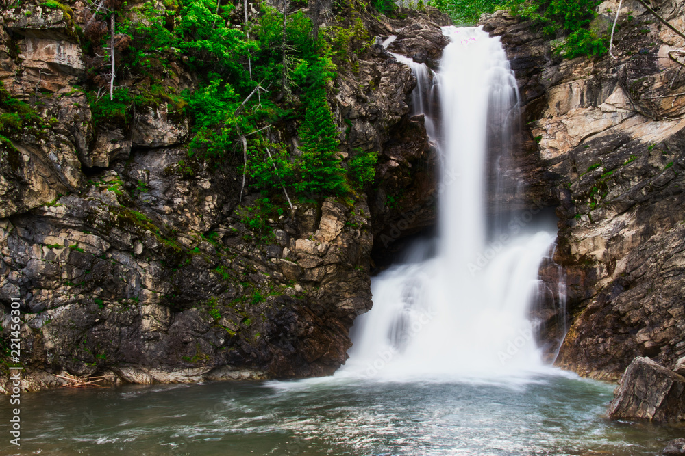 Running Eagle Falls in Glacier Nation Park.  Running Eagle Falls is named after a female warrior of the Amskapi-Pikuni Native American people.  This is a double water fall with both falls flowing in t