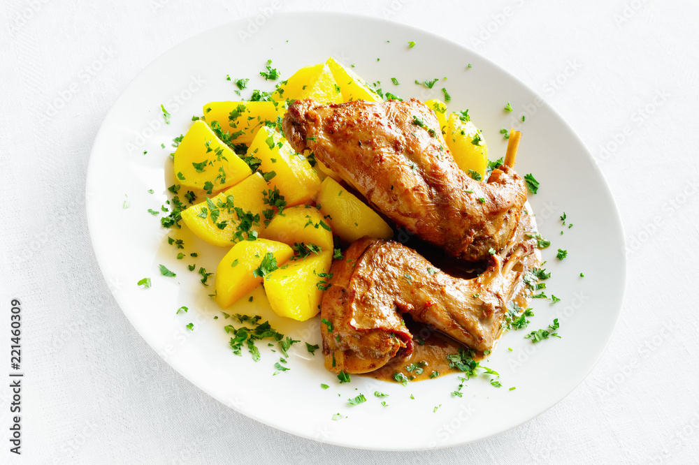 spicy rabbit legs stew with potato sprinkled with parsley spicy rabbit legs stew with potato sprinkled with parsley