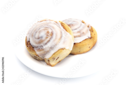 Two Frosted Cinnamon Rolls on a White Plate