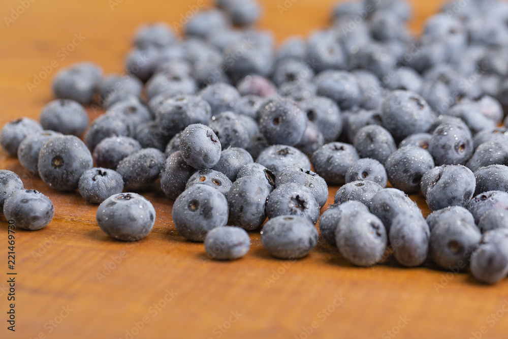 Juicy and fresh blueberries with green mint leaves on a wooden table. Blueberries on wooden background. Juicy and fresh blueberries with green mint leaves on a wooden table. Blueberries on wooden background.