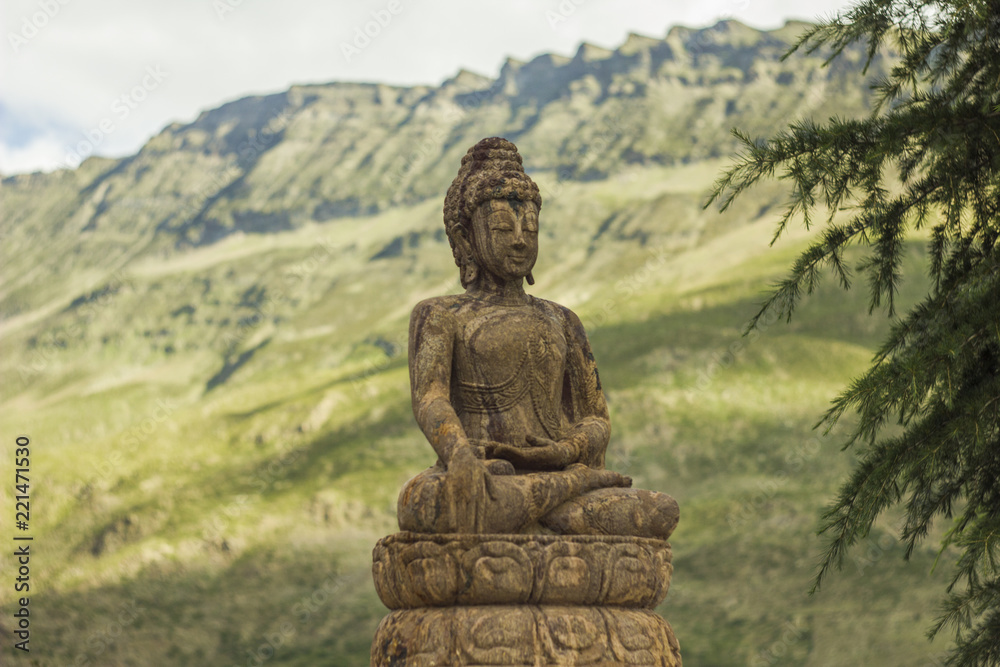 Buddha about fir on the background of mountains