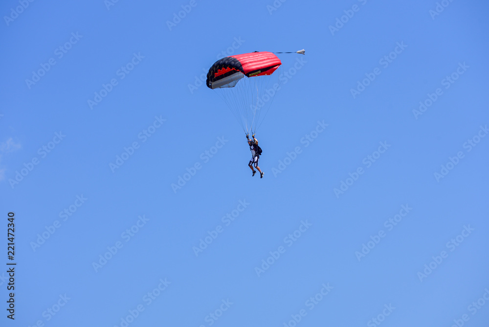 parachutist descends into the blue sky on a sunny day parachutist descends into the blue sky on a sunny day
