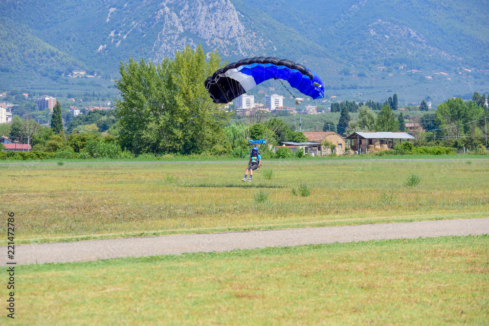 Obraz premium parachutist with yellow parachute lands on the flight field