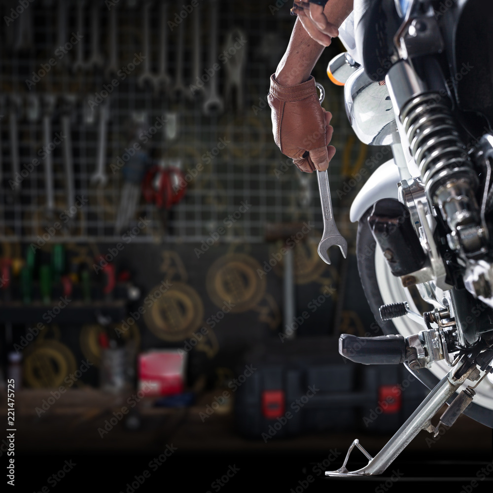 Obraz premium Przycięty widok Mechanika używającego klucza francuskiego na motocyklu