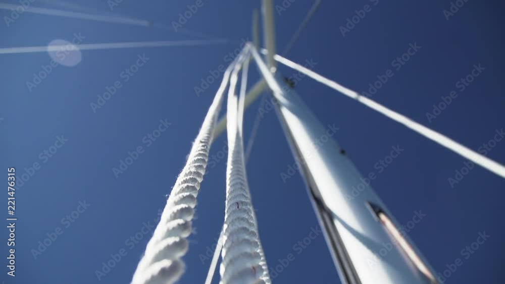 Halyard lines running up mast of large sailboat yacht