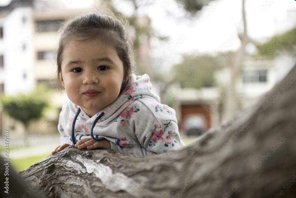 Little girl hugging a tree, looking up Little girl hugging a tree, looking up