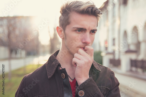 Photos Worried young man biting nails