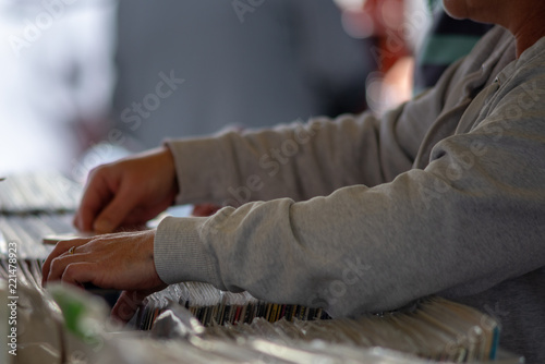 close up of older female hand flicking through vinyl records on a market stall