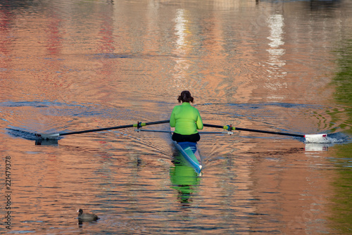 female rower on river in early morning light as part of outdoor sport and exercise regime