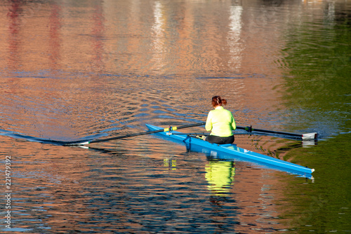 female rower on river in early morning light as part of outdoor sport and exercise regime