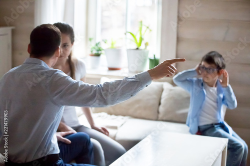 Fotografie Parents argue at home in presence of small child, spouses have fight let little son hear dispute or quarrel, kid suffer from family conflict closing ears