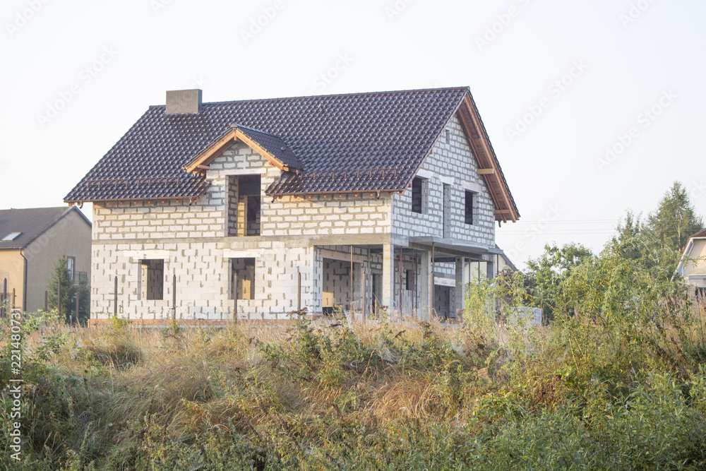 new house under construction stands on top of a hill new house under construction stands on top of a hill