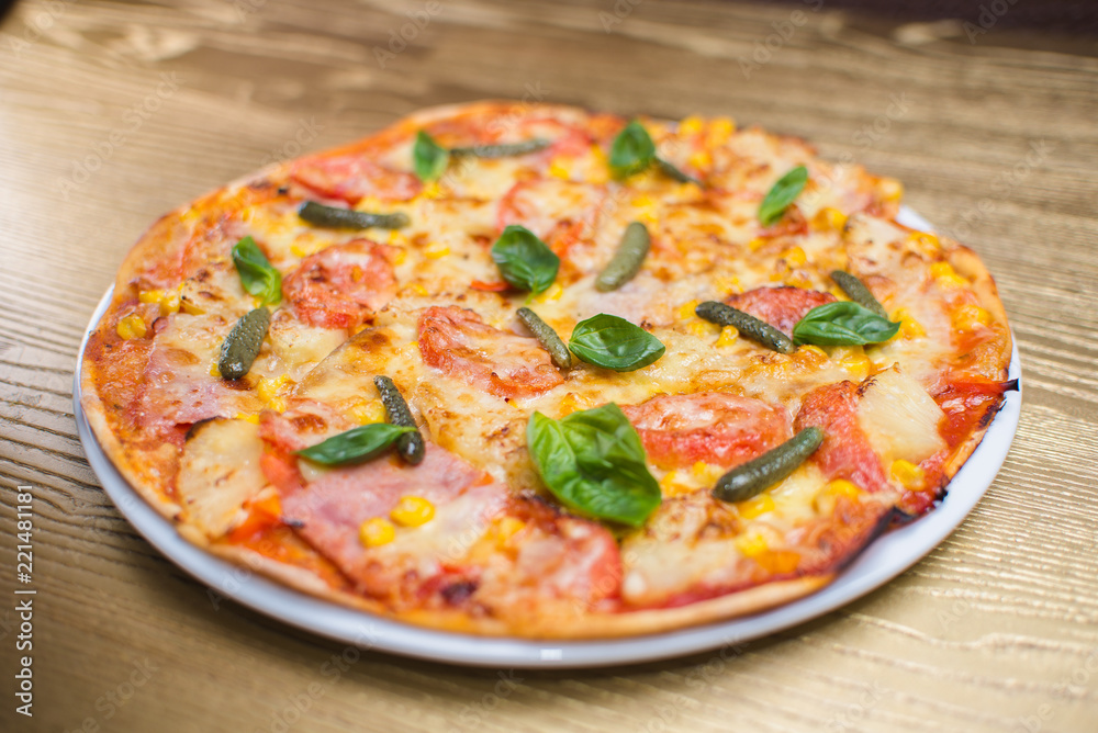 pizza with basil on a white plate