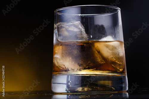 a glass with whiskey and ice on a background