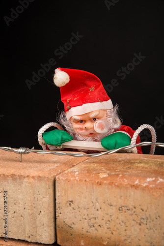 Santa trying to climb the wall photo