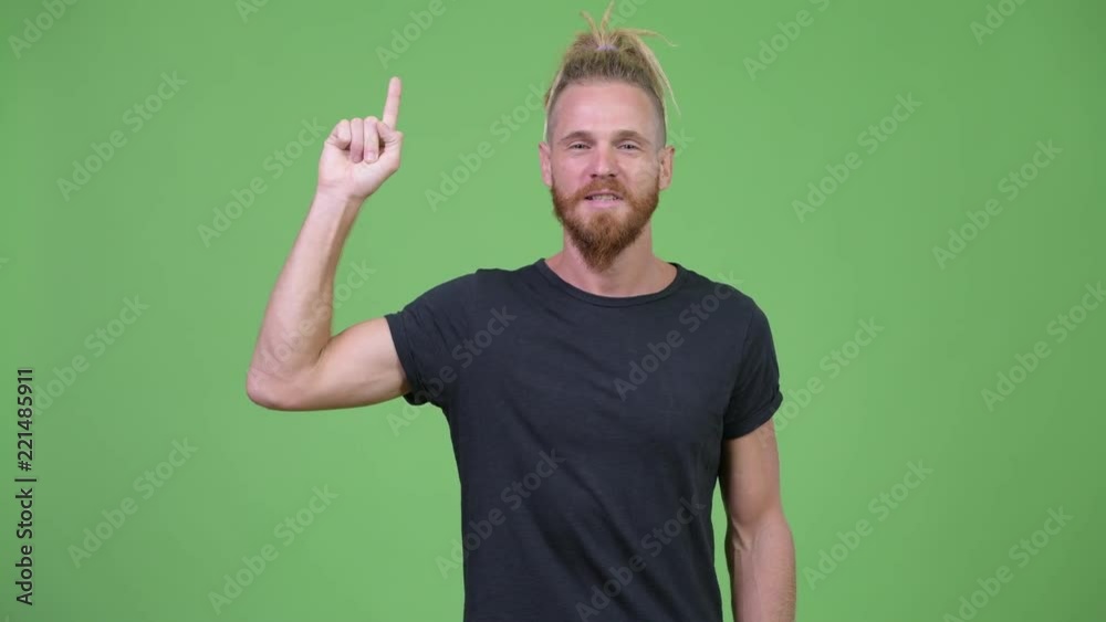 Happy handsome bearded man with dreadlocks pointing up Happy handsome bearded man with dreadlocks pointing up