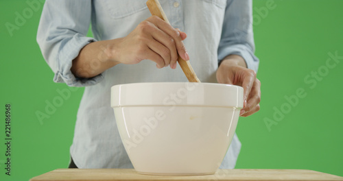 Photography African american woman stirs a mixing bowl with a wooden spoon on green screen