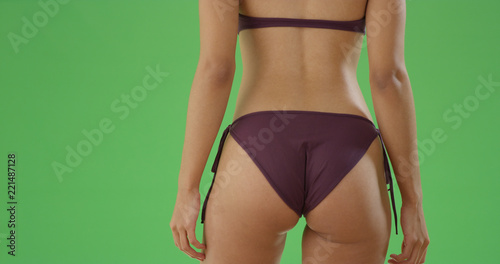 Close-up of a millennial black woman's butt in swimsuit on green screen