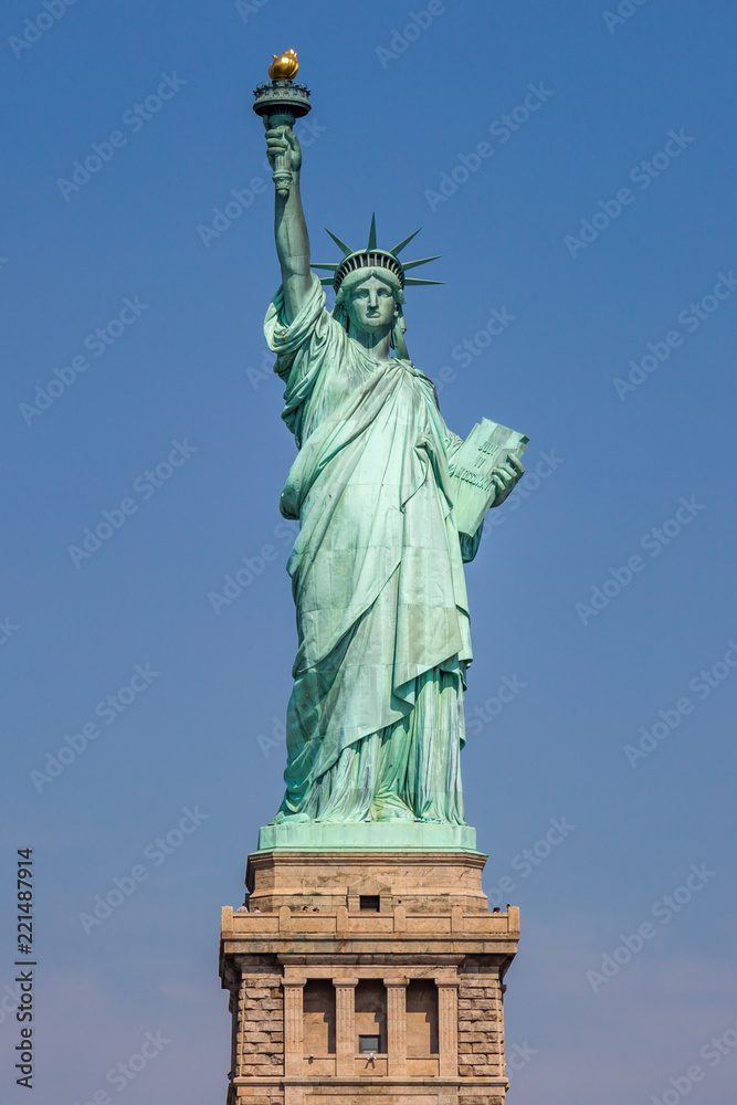 A view of the Statue of Liberty in New York, with a clear blue sky behind