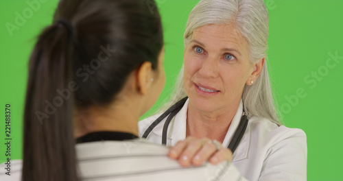 A happy doctor talks to a patient on green screen