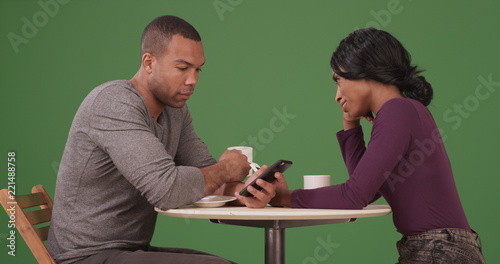 Dating black couple drinking coffee and using smartphones on green screen