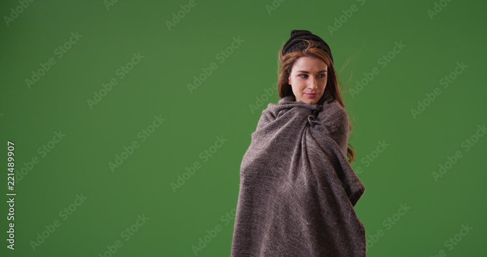 Young woman standing on green screen covered by blanket Young woman standing on green screen covered by blanket