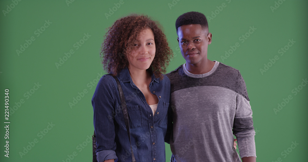 Millennial African American couple pose for a portrait on green screen Millennial African American couple pose for a portrait on green screen