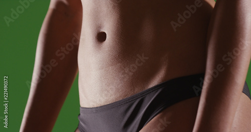 Closeup of woman s flat toned stomach on green screen