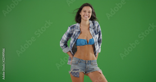 Millennial white woman standing wearing swimsuit and plaid on green screen © rocketclips