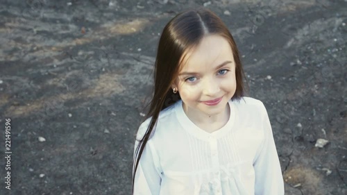 Portrait of young beautiful girl poses at camera on manege photo