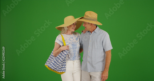 Vacationing elderly white couple wearing sunhats on green screen