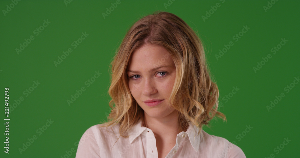 White female dressed in white button shirt looking at camera on green screen White female dressed in white button shirt looking at camera on green screen