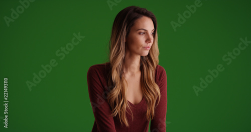 Pensive Caucasian millennial female looking offscreen on green screen © rocketclips