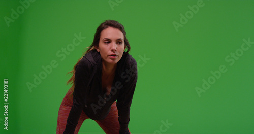 Young Caucasian woman taking break after jog on green screen © rocketclips
