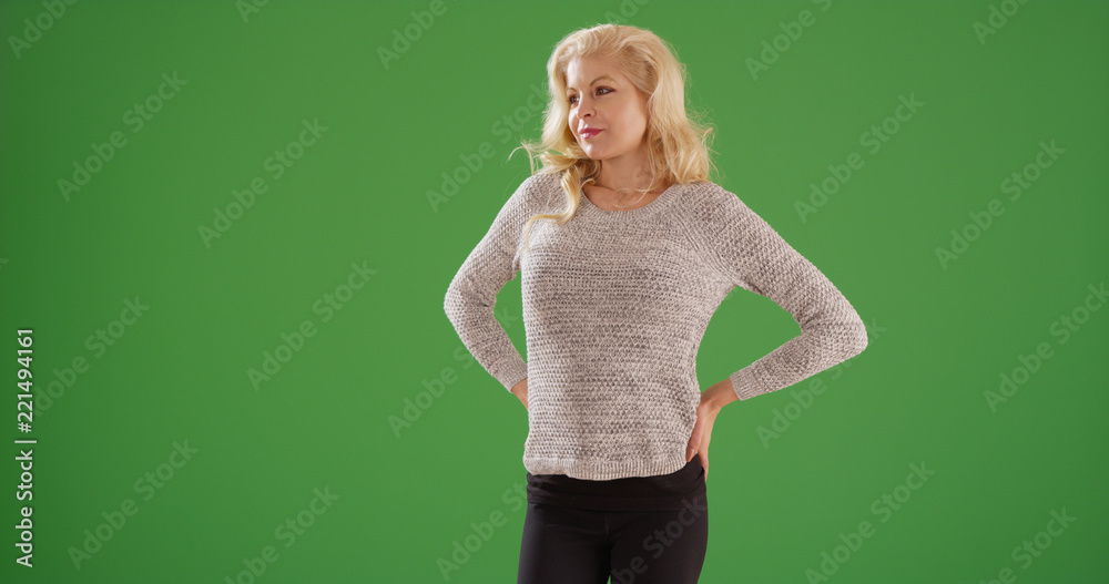 Portrait of white female with hands at hips looking off screen on green screen Portrait of white female with hands at hips looking off screen on green screen