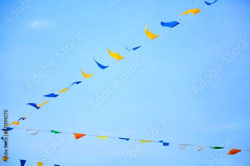 Multicolored triangular festival flags on blue sky background. Outdoor Celebration Party. Festive mood